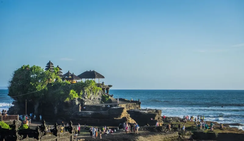 Tanah Lot Temple in Bali at sunset, a famous cultural and spiritual landmark by the sea.