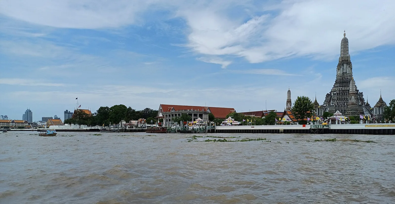 Boats on the Chao Phraya river in Bangkok with the city skyline behind