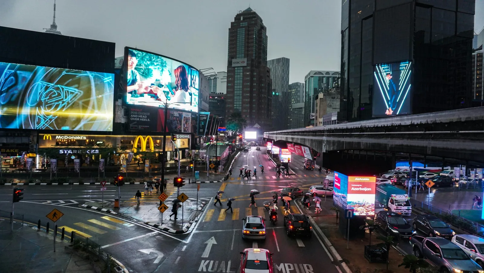 Kuala Lumpur city street at night with lights and traffic.