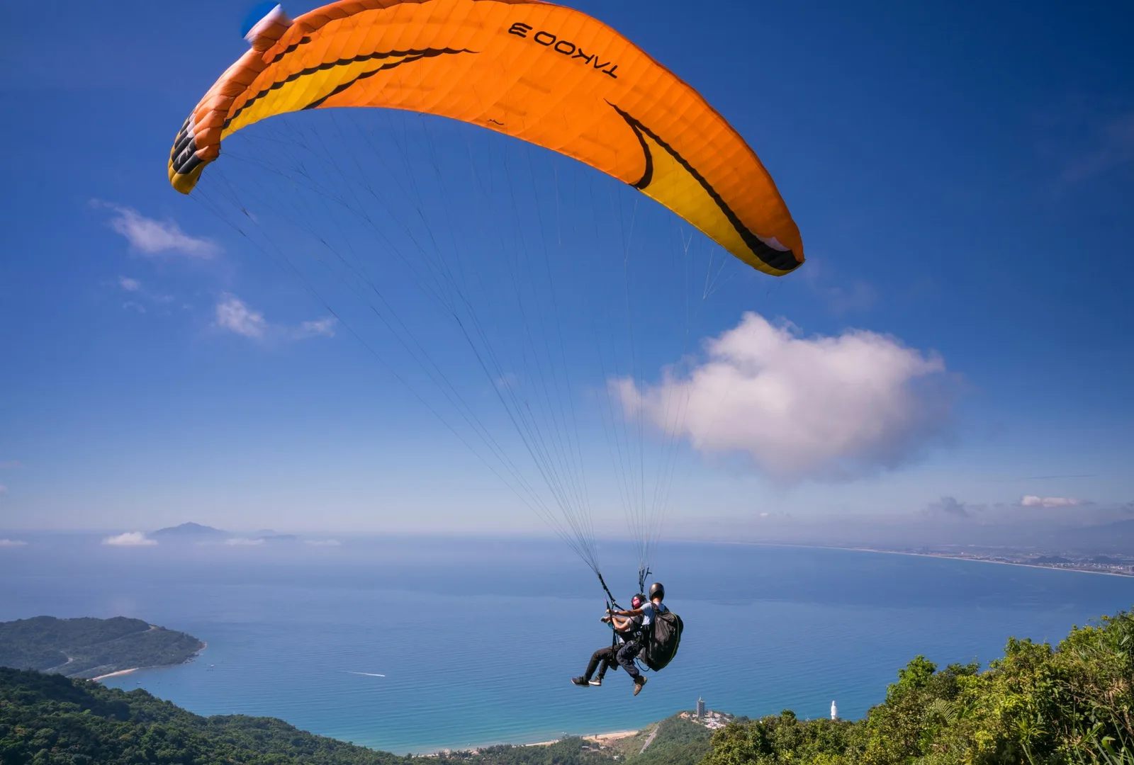 Two people skydiving through dreamy clouds with a breathtaking view of Ronda below.