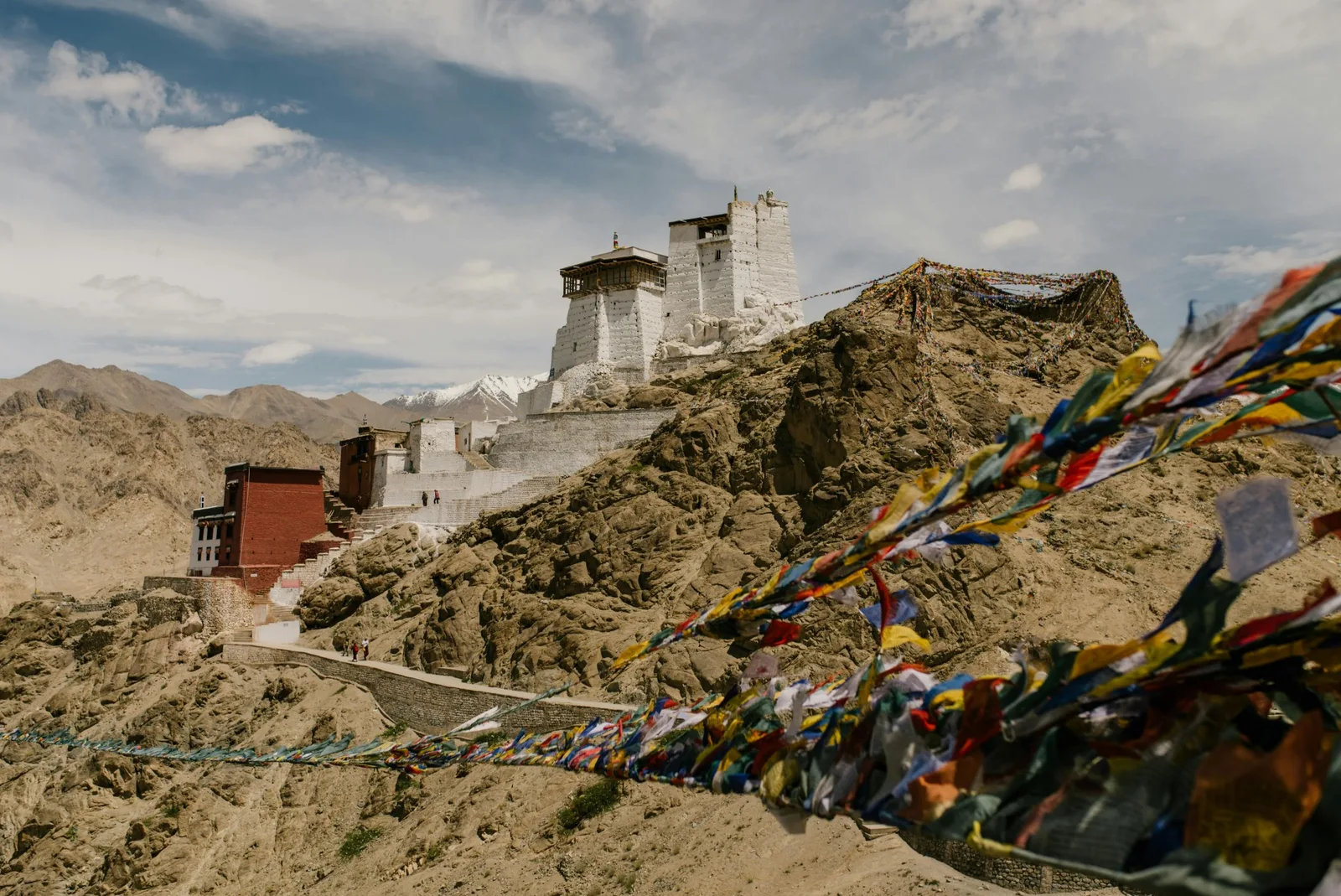 Monastery on a rocky hilltop with prayer flags in Ladakh
